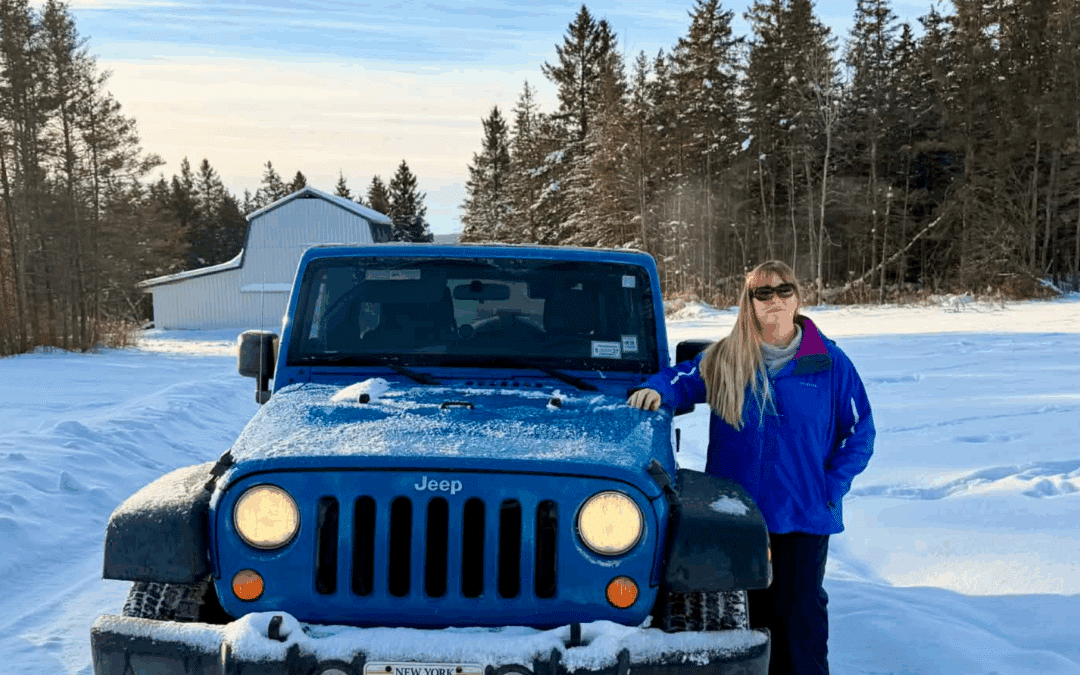 Melissa standing beside her blue Jeep Wrangler on a snowy Western NY back road, symbolizing confidence, traction, and strategic navigation for small businesses – MuseWave Digital
